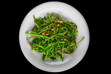 thai fried spinach on a white plate top viewの写真素材