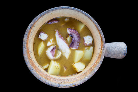 stewed octopus with potatoes in a pot isolated black background top viewの写真素材