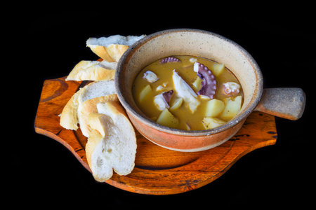 stewed octopus with potatoes in a pot isolated black background side viewの写真素材