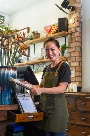 Vietnamese happy waitress working in a kitchen of a cafeの写真素材