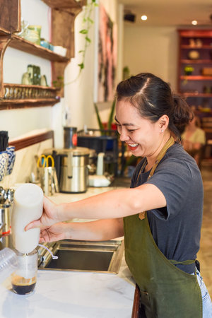 Vietnamese barista pouring condensed milk in glass cup for preparing vietnamese coffee Cafe Suaの写真素材