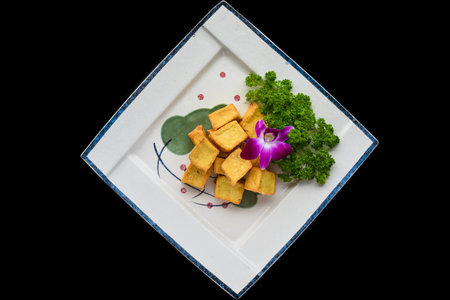 Vietnamese fried tofu on white plate isolated on black background for a menu top viewの写真素材