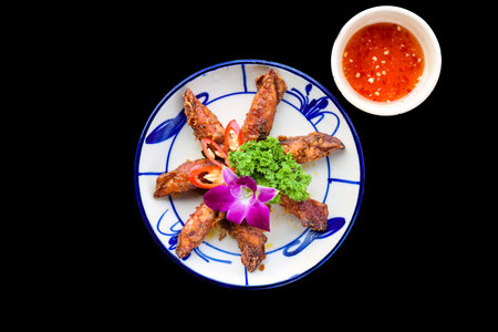 Fried squid with vegetables on black background for a menuの写真素材