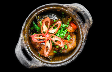 Vietnamese fried Mackerel fish with sauce on black background