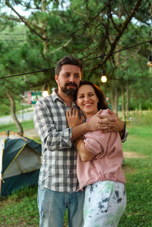 Young married couple emracing and standing in the forest in the eveningの写真素材