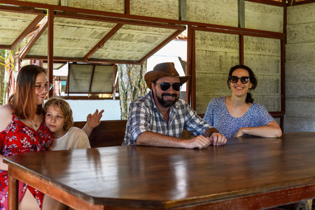 Family members father, mother and two daughters sit in alcove in parkの写真素材