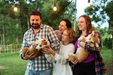 Family members father, mother and two daughters with corgi dogs in the forestの写真素材