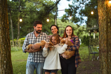Family members father, mother and two daughters with corgi dogs in the forest