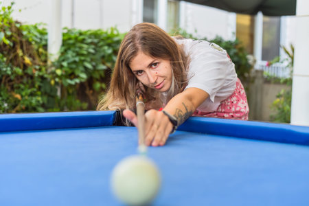 Young blond woman playing billiards in the backyard
