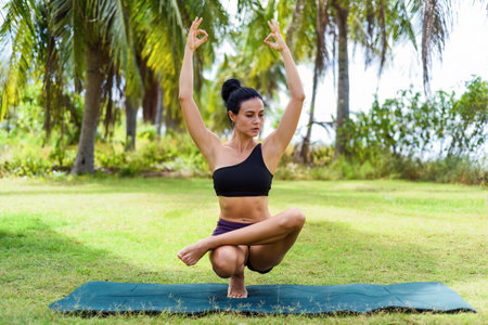 Ardha Baddha Padma or PadangusthasanaÂ  HalfÂ LotusÂ Tip Toe Pose yoga with ukrainian woman making it outdoorsの写真素材