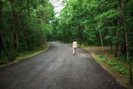 Woman traveler far away walking in the forestの写真素材
