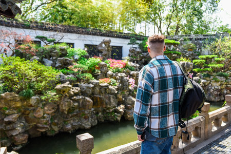Back view of tourist in Yuyuan Garden, Shanghai. Standing alone near rocks and trees, admiring the traditional Chinese landscapeの写真素材