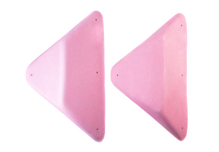 Pair of pink climbing volumes used in indoor rock climbing gyms, featuring triangular shapes and...