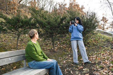 Two Russian women in their 50 years old and 60 years old enjoy an outdoor photo session, showing creativity, mindfulness, active aging and a calm supportive friendship.の写真素材