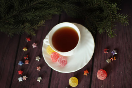 Berry-fruit jelly, tea on a dark wooden background and christmas treeの写真素材