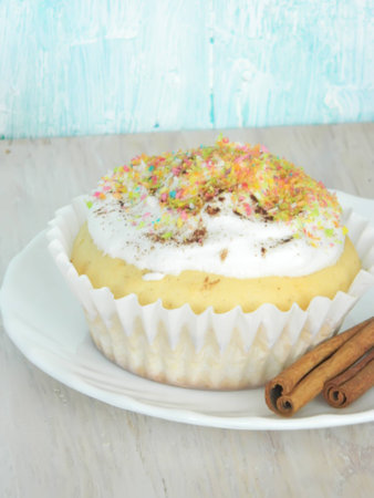 Sweet homemade condensed milk cupcake and cinnamon sticksの写真素材