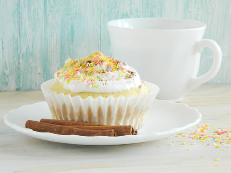 Sweet homemade condensed milk cupcakes, a cup of tea and cinnamon sticksの写真素材