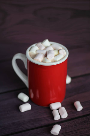 Mug filled with hot chocolate and marshmallows on wooden tableの写真素材