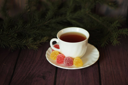 Berry-fruit marmalades, tea on a dark wooden background and christmas treeの写真素材