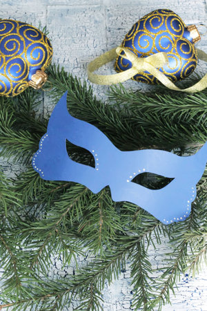 Carnival blue mask on christmas tree branchの写真素材