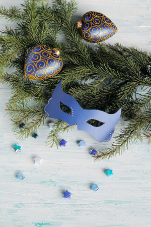Carnival blue mask on christmas tree branchの写真素材