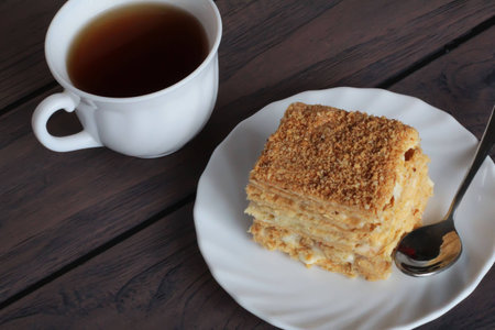 Napoleon cake and a cup of tea on dark wooden backgroundの写真素材