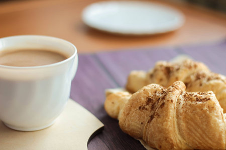 Breakfast with a cup of hot chocolate, croissants on dark wooden background