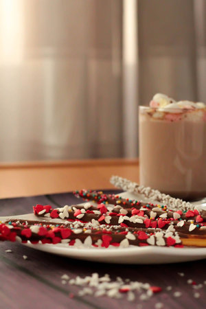 Chocolate cookies sticks with heart shaped topping and hot chocolate with marshmallows in a mugの写真素材