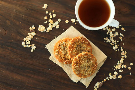 Cookies with sunflower seeds and a cup of tea on dark background top viewの写真素材