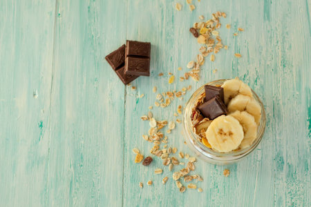 Tasty oatmeal with banana, chocolate and walnuts for breakfast top viewの写真素材