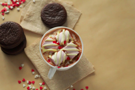 Delicious mini cakes covered with chocolate and hot cocoa with marshmallows on beige background Valentines day celebration top view place for textの写真素材