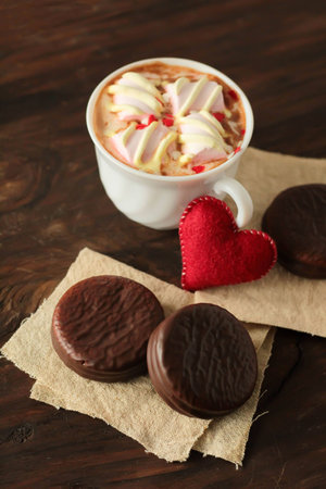 Delicious mini cakes covered with chocolate and hot cocoa with marshmallows on dark background Valentines day celebrationの写真素材
