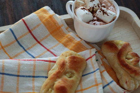 Homemade lemon Buns on napkin and a cup of hot cocoa with marshmallows, cozy backgroundの写真素材