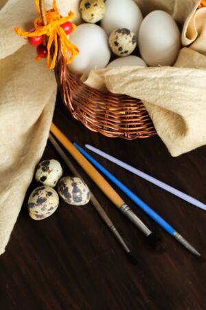 Rustic still life with quail and chicken eggs in a basket ready for decoration on the wooden vintage background for Easterの写真素材