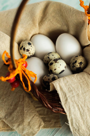 easter eggs in a basket ready for decoration on turquoise wooden board easter backgroundの写真素材