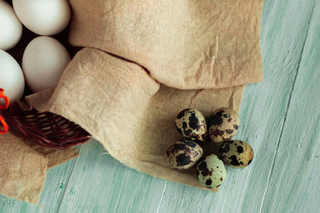 easter eggs in a basket ready for decoration on turquoise wooden board easter backgroundの写真素材