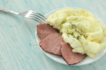 Omlette with pork in a plate on turquoise wooden table. place for textの写真素材