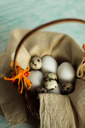 easter eggs in a basket ready for decoration on turquoise wooden board easter backgroundの写真素材
