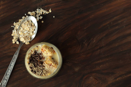 Breakfast smoothie jar topped with chocolate, muesli and sesame seeds. healthy vegan food concept top view place for textの写真素材