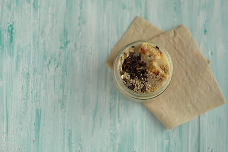 Breakfast smoothie jar topped with chocolate, muesli and sesame seeds. healthy vegan food conceptの写真素材