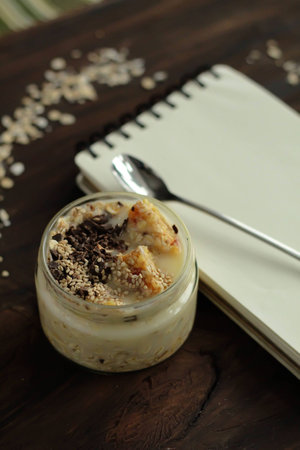 Breakfast smoothie jar topped with chocolate, muesli and sesame seeds. healthy vegan food conceptの写真素材