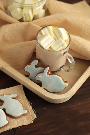mug full of cocoa and hare shaped cookies full of hot cocoa with marshmallows and hare shaped cookies on a dark background Easter celebrationの写真素材