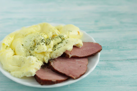 Omelet with pork in a plate on turquoise wooden table.の写真素材
