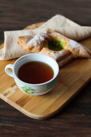 Breakfast with tea and puff with kiwi jam on wooden tableの写真素材