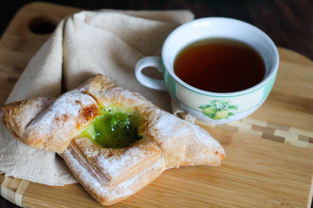 Breakfast with tea and puff with kiwi jam on wooden table sweet breakfastの写真素材