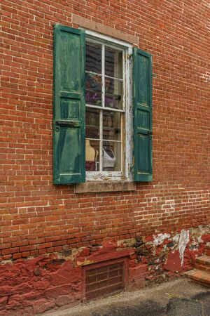 Old house red wall with green wooden windowの写真素材