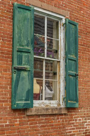Old house red wall with green wooden windowの写真素材