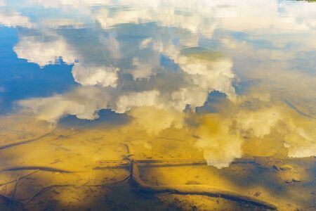Reflection in the water of the sky and the bottom of the riverの写真素材