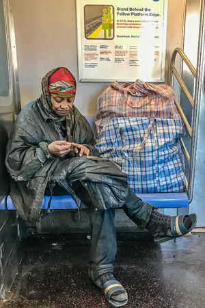 Manhattan, NY US - March 19, 2018 Homeless person sits in a subway carのeditorial素材