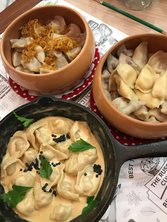 3 types of dumplings in a pan and plates. Dumplings, filled with meat, ravioli, pelmeni.の写真素材